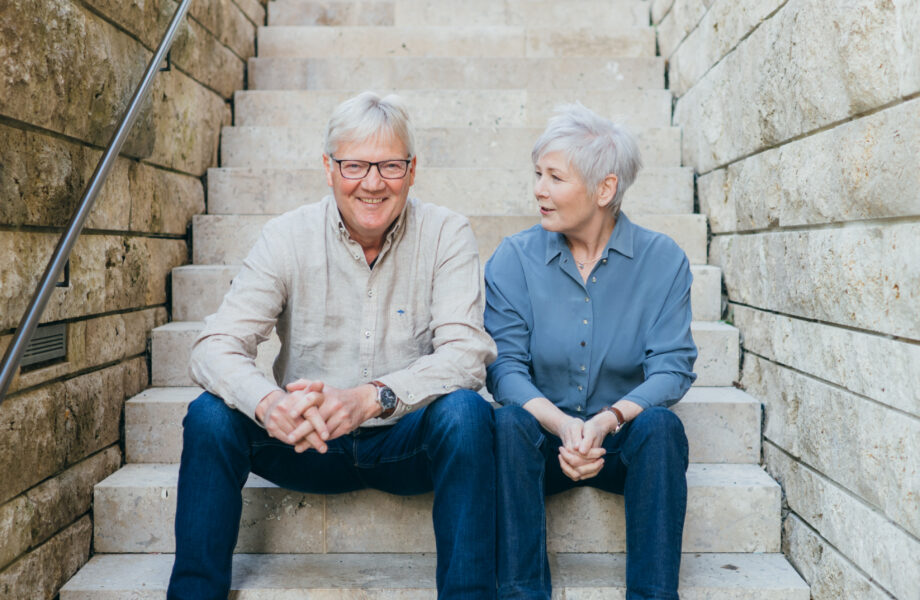 Anne Alsfasser und Werner Niederquell im Portrait auf einer Treppe sitzend. Sie reden zum Thema Management Essentials Organisationsdiagnose miteinander